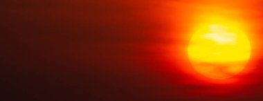 Gün batımında göz kamaştırıcı turuncu bir gökyüzü manzarası.