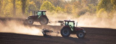 With the help of a sturdy tractor, a cultivator breaks up the soil, ensuring optimal conditions for crop growth clipart