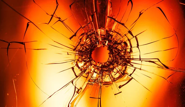 The Torn Veil: A Bullet\'s Mark on Glass Amid an Infern
