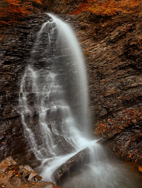 Falling Gold: Autumn\'s Waterfall Jewel in Mountain Splendor