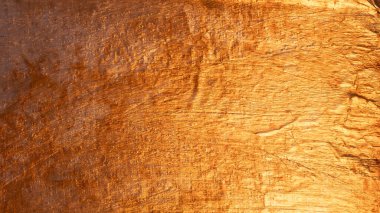 Parlak ve buruşuk metalik bir yüzeyi gösteren altın arkaplan dokusu