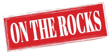 Kayalarda kırmızı dikdörtgen damga işareti üzerine yazılmış metin.