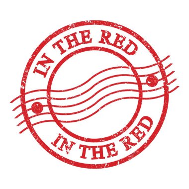 IN THE RED, text written on red grungy postal stamp.
