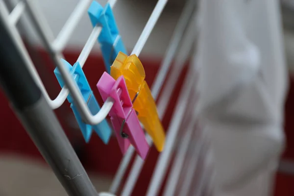 stock image A portrait of two colorful washingpins hanging on a laundry rack without any wet clothes on it to dry.