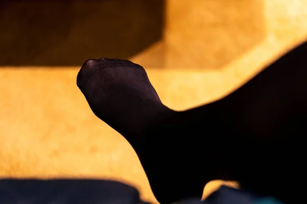 Close up portrait of the black nylon feet of a woman dressed in stockings  or pantyhose