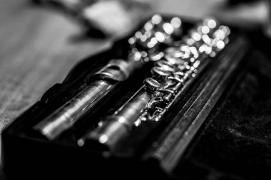 Parçalanmış gümüş flüt kapakçığının siyah beyaz portresi. Bir flütçünün veya müzisyenin bir parça çalabilmesi için enstrümanın tekrar bir araya getirilmesi gerekiyor..