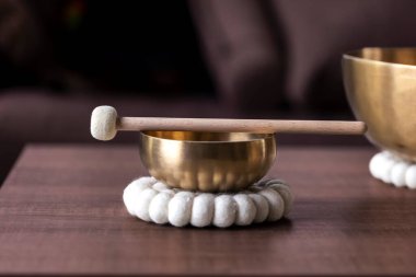 Tibet şarkı kasesinin yakın çekimi ya da Himalaya kasesinin tepesinde gevşetici bir ses çıkarmak için duran bir tokmak. Nesne rahatlama, meditasyon ve stresi azaltmak için kullanılır..