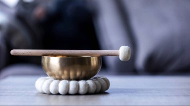 Tibet şarkı kasesinin yakın çekimi ya da Himalaya kasesinin tepesinde gevşetici bir ses çıkarmak için duran bir tokmak. Nesne stres ve meditasyonu rahatlatmak için terapi için kullanılır..