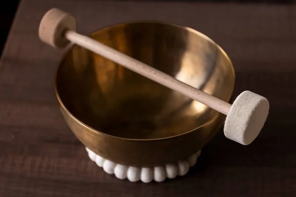 Stock image Portrait of a large himalayan bowl, also called a singing bowl, with a mallet lying on top of it to make a relaxing sound. The object is used for relaxation, meditation and therapy to relieve stress.