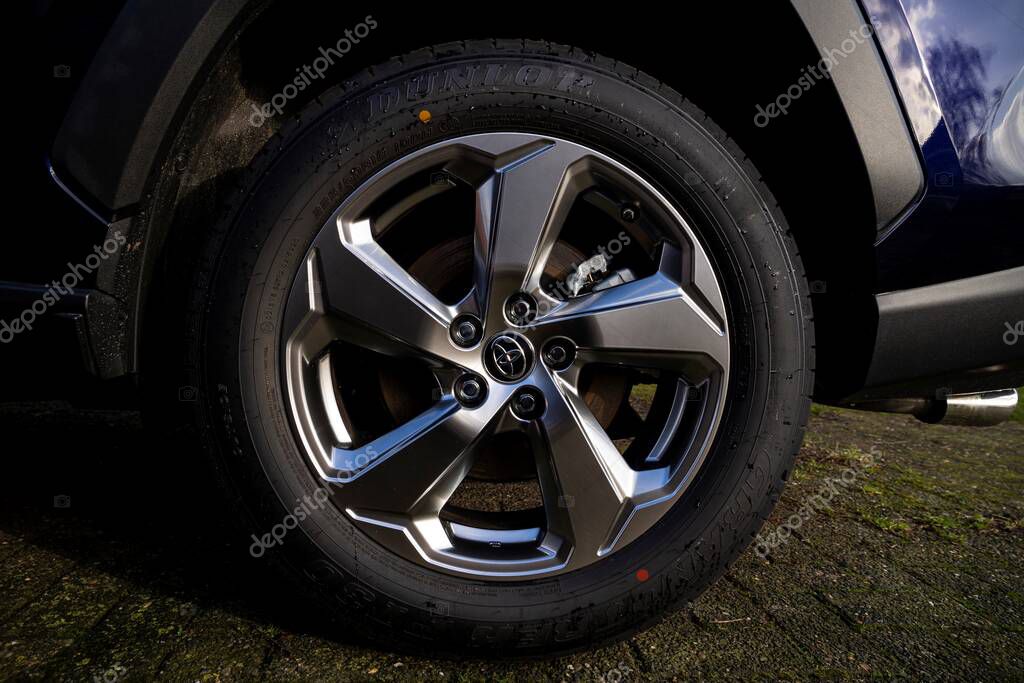 Brecht, Belgium - 5 february 2022: A portrait of a toyota rav 4 wheel, rim and tire with the logo in the middle standing on a drive way.