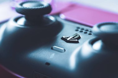 Brecht, Belçika - 14 Temmuz 2023: PS5 logosu ve resmi bir kozmik kırmızı playstation 5 video oyun kontrolörünün yakın plan portresi.