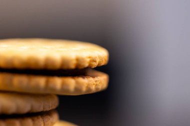 Mutfak tezgahının üstüne düşmüş yuvarlak lezzetli kurabiyelerin makro portresi. Lezzetli atıştırmalıkların her iki tarafında da bisküvi var ve içi çikolata kremasıyla dolu..
