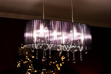 Lüks bir kristal avize loş bir odada sıcak bir parıltı yayarak zarif ve sofistike bir atmosfer yaratır. İç tasarım ilhamı için mükemmel.