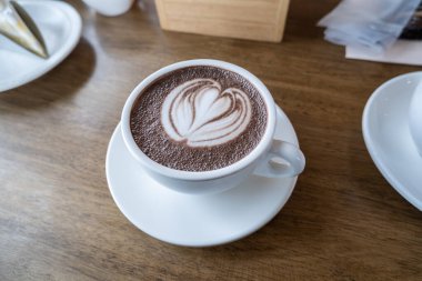 Kahve, güzel dekore edilmiş, temiz beyaz bir fincanda..