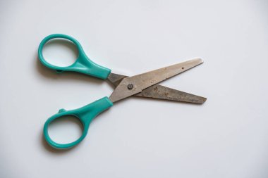 Eski paslı makas, yeşil saplı, beyaz arka planda..