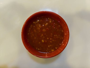 Sukiyaki sosu küçük kırmızı bir fincana konur. beyaz arkaplanda