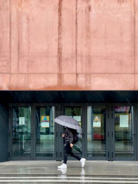 Şemsiyeli ve modern bina geçmişi olan bir adam.