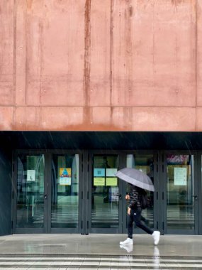 Şemsiyeli ve modern bina geçmişi olan bir adam.