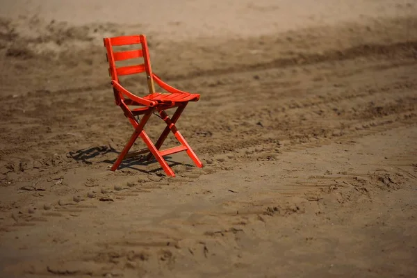 Isolated red wooden chair on a beach in Vieste