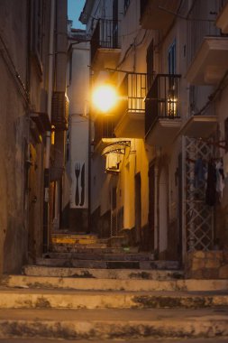 Geceleyin geniş merdivenlerle aydınlatılmış tarihi bir sokak.