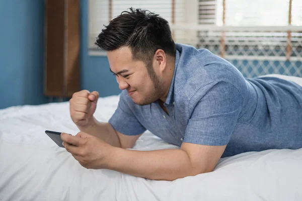 Молодой Азиат Плюс Крупный Мужчина Играет Видеоигру Мобильном Телефоне Реагирует — стоковое фото