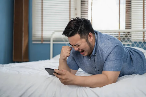 Молодой Азиат Плюс Крупный Мужчина Играет Видеоигру Мобильном Телефоне Реагирует — стоковое фото