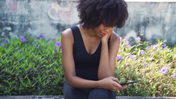 Młoda Afroamerykanka Używająca Telefonu Komórkowego Siedząca Ławce Parku Kobieta Czarny — Wideo stockowe