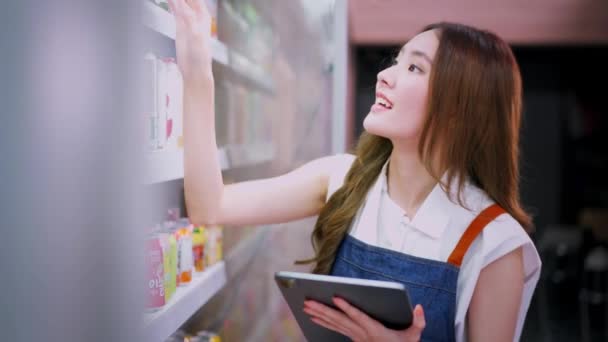 Joven Supermercado Asiático Empleado Tienda Verificación Calidad Del Artículo Mientras — Vídeos de Stock
