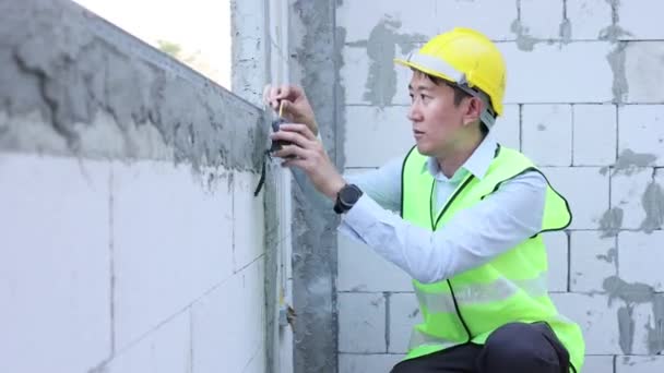 Joven Ingeniero Asiático Uniforme Ingeniería Casco Sitio Construcción Utilizando Una — Vídeos de Stock