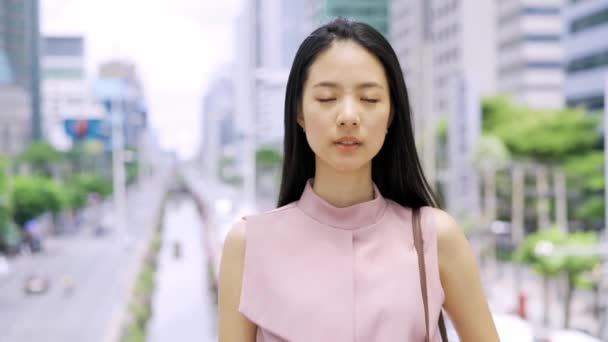 カメラを見ている若いアジアの実業家は 都市のオフィスビルを笑顔にします 中国の韓国アジアのスマートな女性の肖像画ビデオ 4Kの良質の映像 — ストック動画