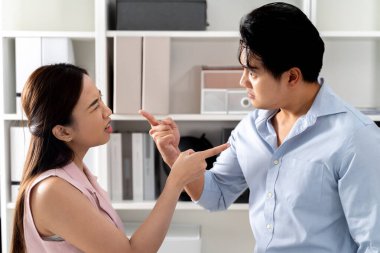 Kızgın Asyalı iş kadını ofis odasında deli bir iş adamına bağırıp azarlıyor. Birbirlerini parmakla gösteriyorlar. - İş kavgası ve iş yeri kavramında çatışma.