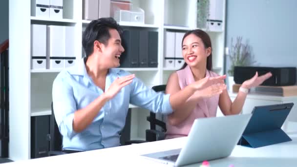 アジアのビジネスマンと女性は オフィスのコンピュータラップトップとタブレットで机の上に座っている間 幸せと成功のお祝いの笑顔とダンスを楽しみました 成功し 楽しい職場 — ストック動画