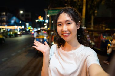 Mutlu Asyalı yalnız hipster gezginin portresi selfie çekiyor ya da Bangkok, Tayland 'da sokakta mutlu bir gülümsemeyle video kaydediyor. Güneydoğu Asya 'yı keşfeden kadın turist.