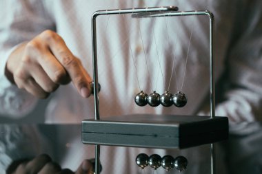 Tanınmaz işadamı Newton beşik küçük metal topu çekerek ve cam masa üzerinde momentum gözlem