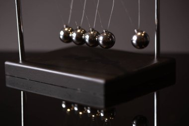 Closeup metal Newton beşiği momentum kavramı gösterimi olarak gri arka plan üzerine yerleştirilen
