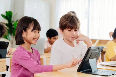 Uluslararası Öğrenciler Tablet Üzerine İşbirliği Yapıyor: Çeşitli İlköğretim Sınıfı Sahnesi Sayısal Öğrenim ve Çok Kültürlü Eğitim Eylemlerini Gösteriyor