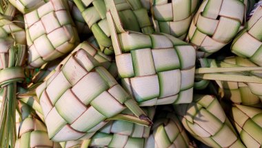 Ketupat adında özel bir bayram yemeği. Olgun Ketupat Yapraklara Sarılmış. Ketupat, Kurban Bayramı 'nda tipik bir yemektir.