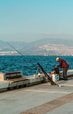 İzmir, Türkiye - 7 Kasım 2022 - İzmir Körfezi kıyısında balık tutan balıkçıların gizli fotoğrafları
