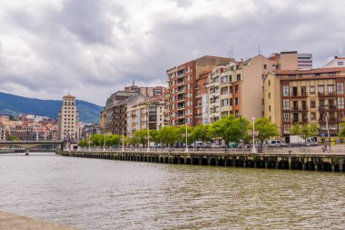 Bilbao, İspanya - 1 Temmuz 2024 - Kasvetli bir günde Nervion nehri üzerindeki binalar