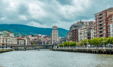 Bilbao, İspanya - 1 Temmuz 2024 - Kasvetli bir günde Nervion nehri üzerindeki binalar