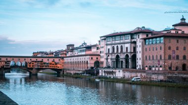 Floransa, İtalya - 14 Aralık 2024 - Arno Nehri 'nin arka planda Ponte Vecchio ile güzel günbatımı manzarası