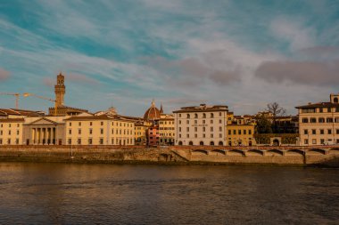 Floransa, İtalya - 14 Aralık 2024 - Palazzo Vecchio ile Arno Nehri 'nin güzel gün batımı manzarası