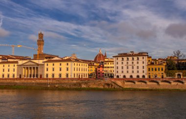Floransa, İtalya - 14 Aralık 2024 - Palazzo Vecchio ile Arno Nehri 'nin güzel gün batımı manzarası