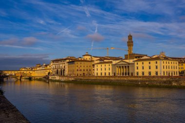 Floransa, İtalya - 14 Aralık 2024 - Palazzo Vecchio ile Arno Nehri 'nin güzel gün batımı manzarası