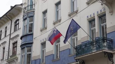 Slovenya 'nın orta Ljubljana kentinde bir binada Sloven ve Avrupa Birliği bayrağı