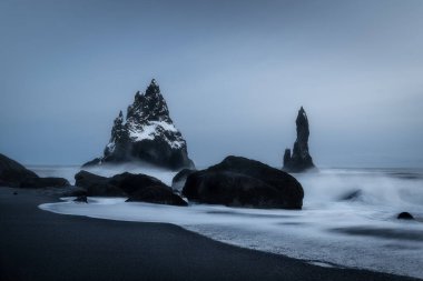 Reynisfjara ya da Reynisdrangar ya da Kara Kum Sahili, kasvetli bir günde İzlanda 'da volkanik bir plaj.