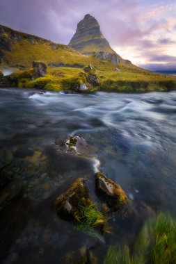 Majestic Dağı Kirkjufell, gün doğumunda İzlanda 'da. Önde uzun pozlama nehri, dikey yönelim.