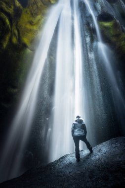 Gljufrabui şelalesi İzlanda 'da bir kanyonun içinde, tanınmayan bir insanla birlikte, doğal mucizeye hayran.