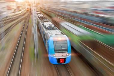 Şehir treninin farları tren raylarının üzerinde, üst hava manzaralı.