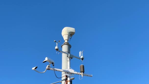 観測用の気象監視システムとビデオカメラ 青い空の雲を背景にした自動気象ステーション — ストック動画